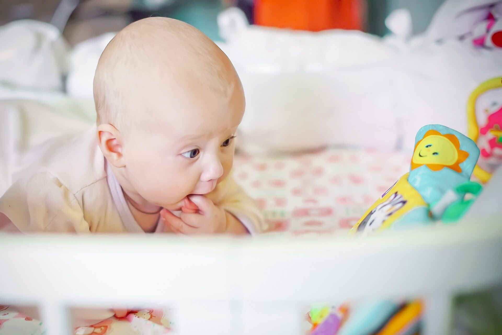 newborn baby looks at the developing toy with surprise.
